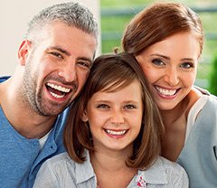 Mother father and daughter smiling