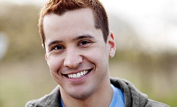 Young man with short brown hair smiling