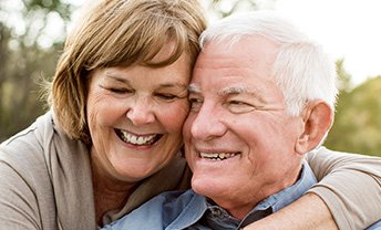 Senior man and woman smiling together outdoors