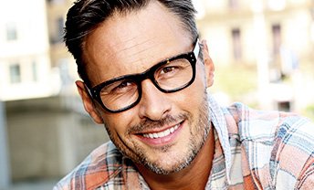 Man in glasses and red plaid shirt smiling