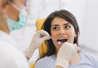 Woman having her teeth examined