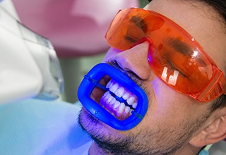 Man in dental chair receiving professional teeth whitening