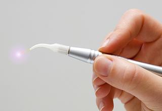 Hand holding a dental laser wand