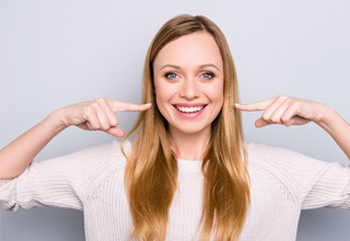 Woman pointing to her smile