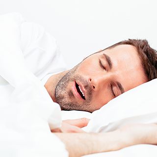 Bearded man lying in bed in need of snoring treatment in Inner Grove Heights