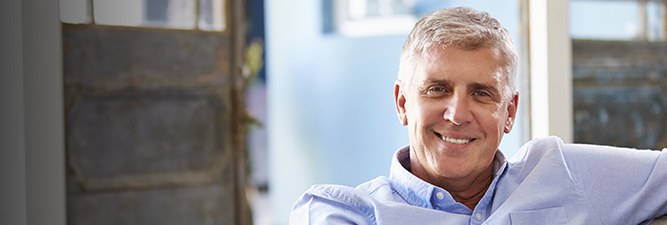 Smiling man in pale blue collared shirt